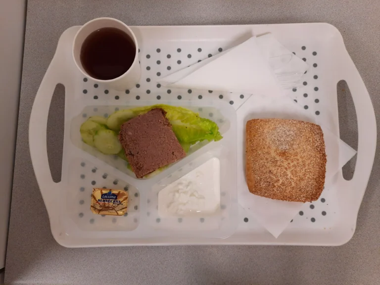 Śniadanie, dieta podstawowa: herbata czarna b/c -250ml, bułka graham-100g (gluten), margaryna 60% tł 10 g, pasztet drobiowy 40 g (jaja, gluten, seler), serek wiejski 40 g (mleko), sałata rzymska 20 g, ogórek świeży b/s 80 g