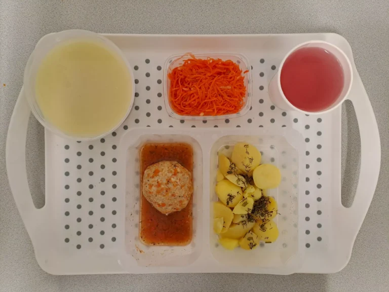 Obiad, dieta podstawowa: kompot owocowy b/c 250 ml, zupa wielowarzywna z kaszą pęczak 400ml (seler, gluten, mleko), klopsiki drobiowe gotowane 80 g (gluten, jaja, mleko), sos koperkowy 50 ml (gluten, mleko), ziemniaki gotowane 200 g, surówka z marchwi i jabłka 150 g