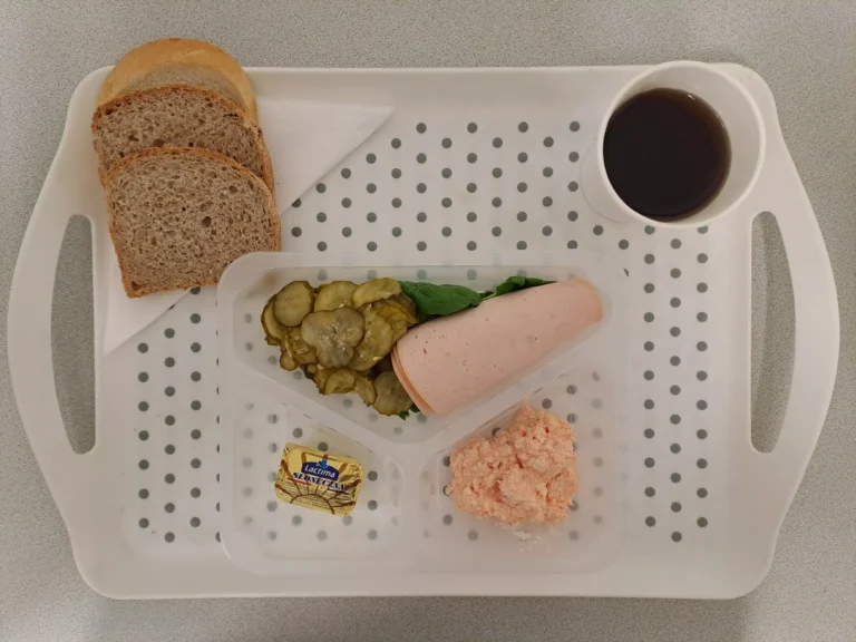 Śniadanie, dieta podstawowa: herbata czarna b/c  - 250ml, chleb graham - 70g (sezam, gluten), chleb pszenny- 30g (gluten), margaryna 60 % tł. 10 g, szynka z indyka 40g (soja), pasta z twarogu i papryki 40 g (mleko), szpinak liście 10 g, ogórek konserwowy 80 g (gorczyca)